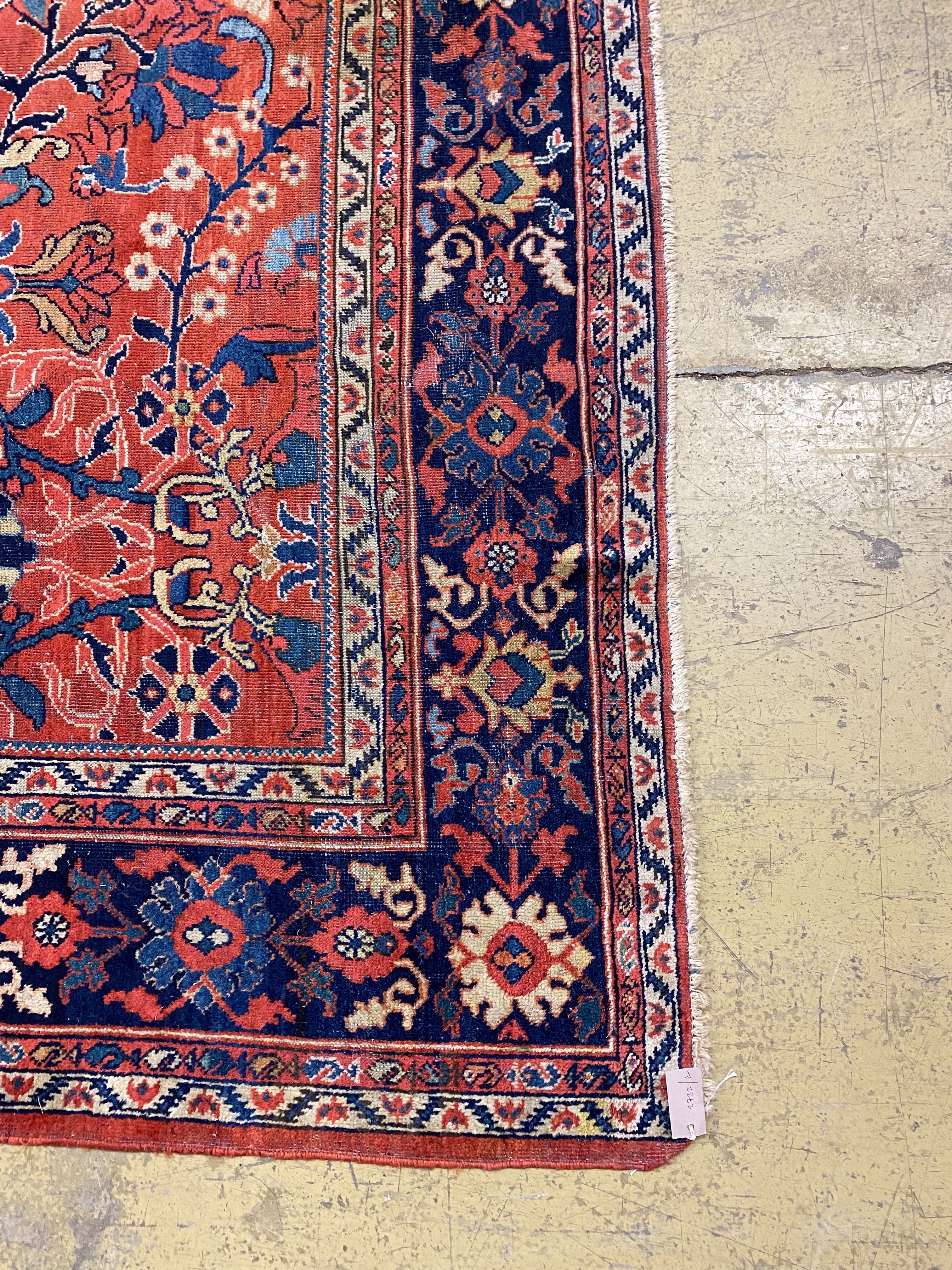 A Heriz brick red ground carpet, 364 x 280cm